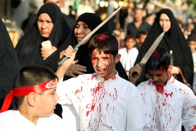 Iraqi Shiite boys take part in a self-flagellation ceremony during a parade ahead of Ashura in Baghdad's northern district of Kadhimiya on October 23, 2015. Ashura mourns the death of Imam Hussein, a grandson of the Prophet Mohammed, who was killed by armies of the Yazid near Karbala in 680 AD. AFP PHOTO / AHMAD AL-RUBAYE